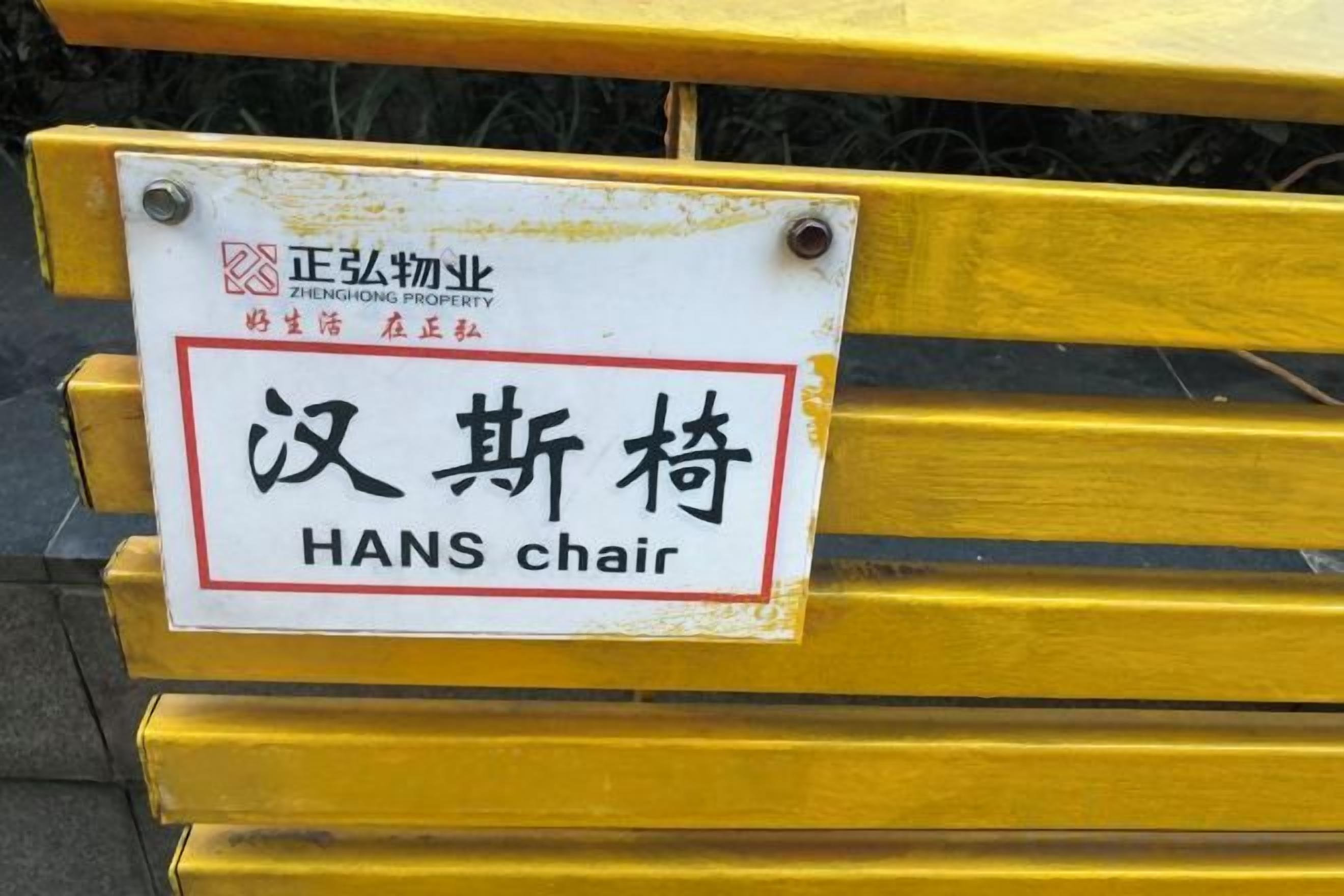 A yellow chair with a sign that reads 'HANS chair' and some Chinese characters.