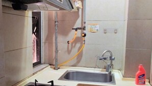 Une cuisine équipée d’une cuisinière à gaz, d’un évier et d’une fenêtre.