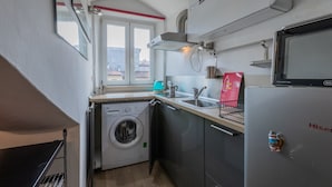 Cocina compacta con lavadora, lavaplatos y refrigerador.