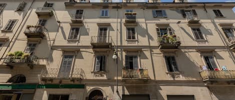 A multi-story building with balconies, a garage door, and graffiti.