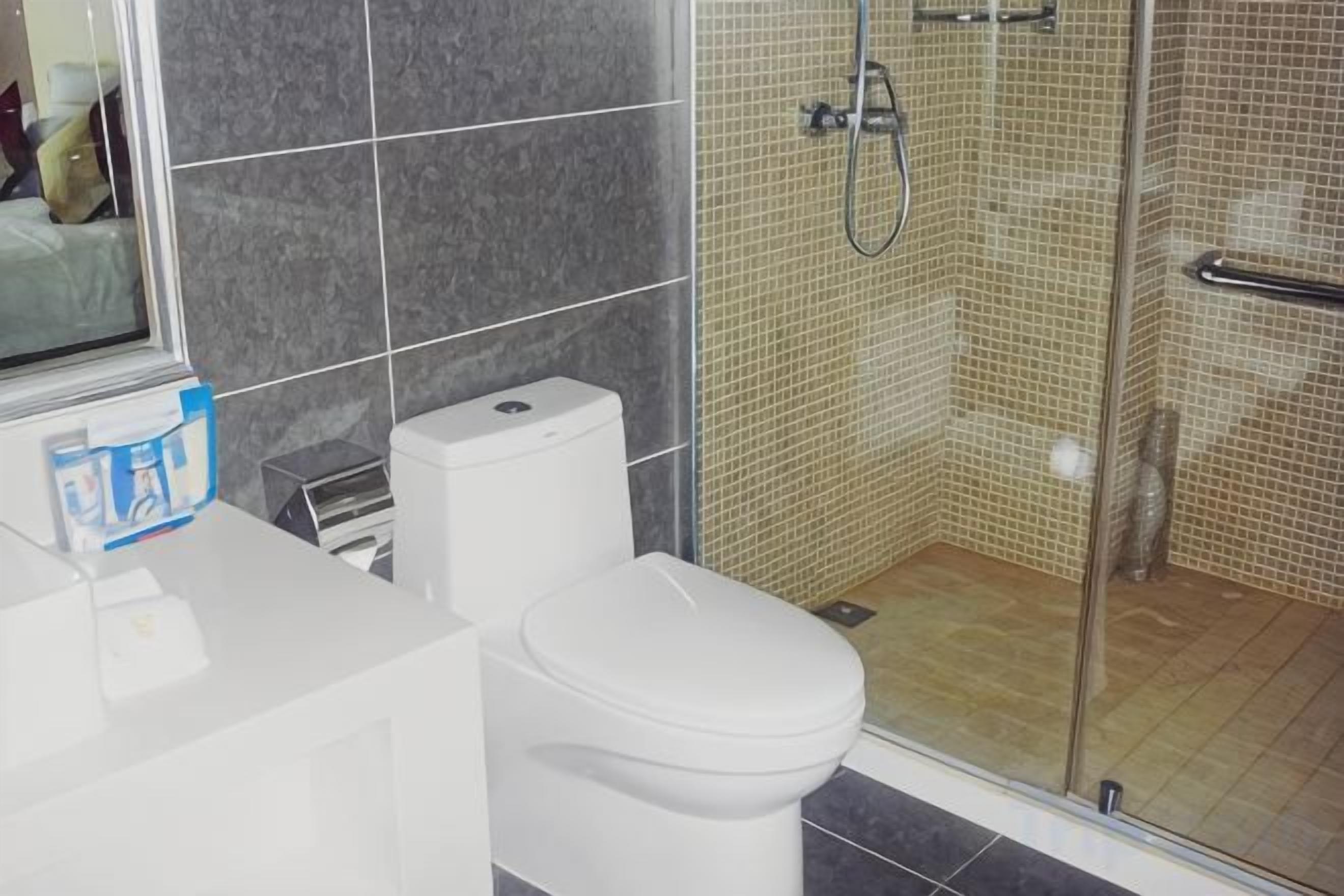 Une salle de bain comprenant des toilettes, un espace douche et un lavabo.