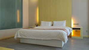 Un dormitorio moderno con una cama grande, mesitas de noche y una ventana con persianas.