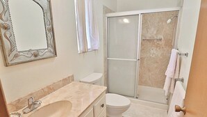 Un baño con lavamanos, inodoro y ducha.