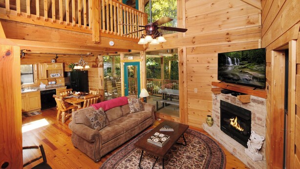 A wooden cabin interior with a living room, kitchen, and dining area. - 3 BR/3 bath (sleeps 8) located between GBurg & PF! Hot tub, pool table, privacy! (Sevierville)