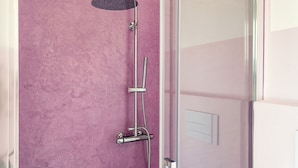 A shower with a handheld showerhead and a wall-mounted faucet. - Sardegna è - Beach Rooms (Olbia)