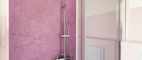 Eine Dusche mit Handbrause und Wandarmatur.