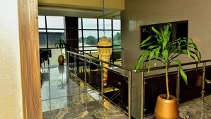 A spacious lobby with a marble floor, a large chandelier, and a potted plant.