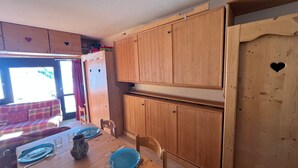 Eine kleine Küche mit Holzausstattung und einem Esstisch für zwei Personen.