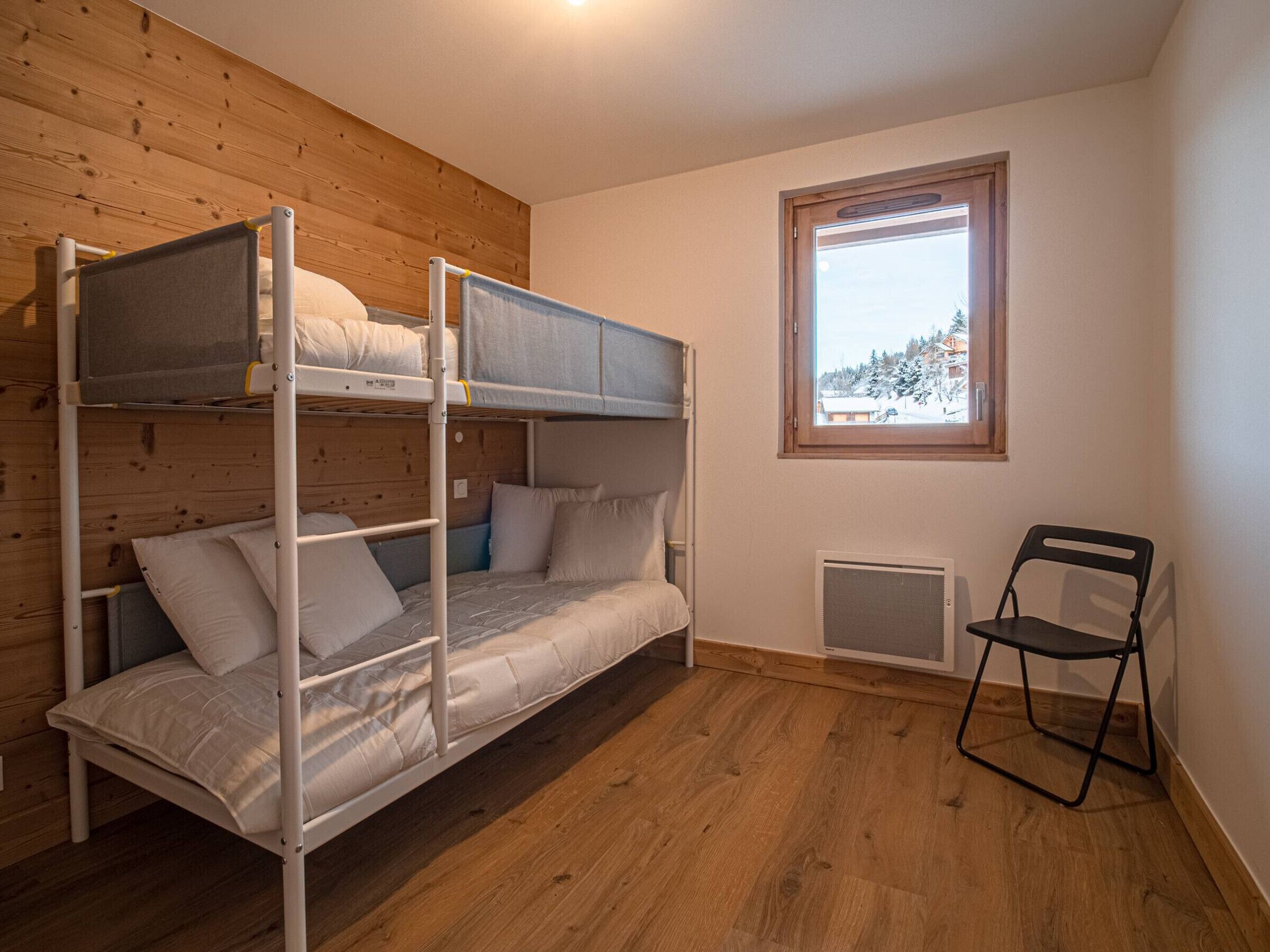 A bunk bed room with a window and a radiator.