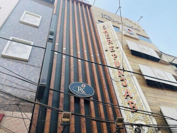 A hotel facade with vertical wooden slats, a prominent 'R' logo, and the name 'Sahera' in decorative script.