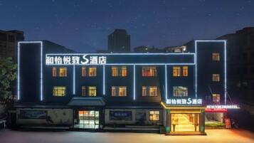Un hotel con varios pisos y una fachada bien iluminada.