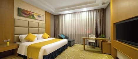 A hotel room with a bed, desk, chair, TV, and curtains.