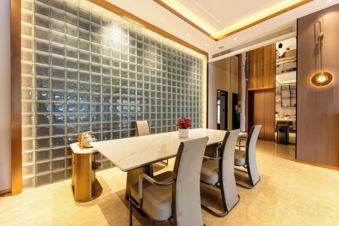 Un comedor moderno con un separador de vidrio, una mesa de mármol y sillas contemporáneas.