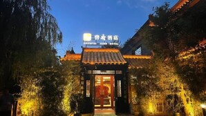 The Oriental Zen Hotel entrance with traditional Chinese architecture, illuminated signage, and a well-maintained garden. - Oriental Zeng Hotel (Beijing)
