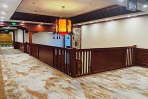 A hotel lobby with a reception desk, a patterned carpet, and a ceiling with recessed lighting. - Oriental Zeng Hotel (Beijing)
