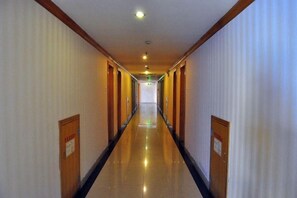 A long, narrow hotel corridor with doors on both sides, leading to rooms. - Yijing Hotel (Guangzhou)