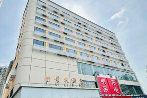 A multi-story hotel building with a modern architectural design, featuring a prominent signboard at the ground level. - Yijing Hotel (Guangzhou)