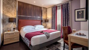 A modern hotel room with a large bed, bedside tables, a desk, and a chair. - The Inn at the Spanish Steps Exclusive Collection - Condotti Luxury Suites (Rome)