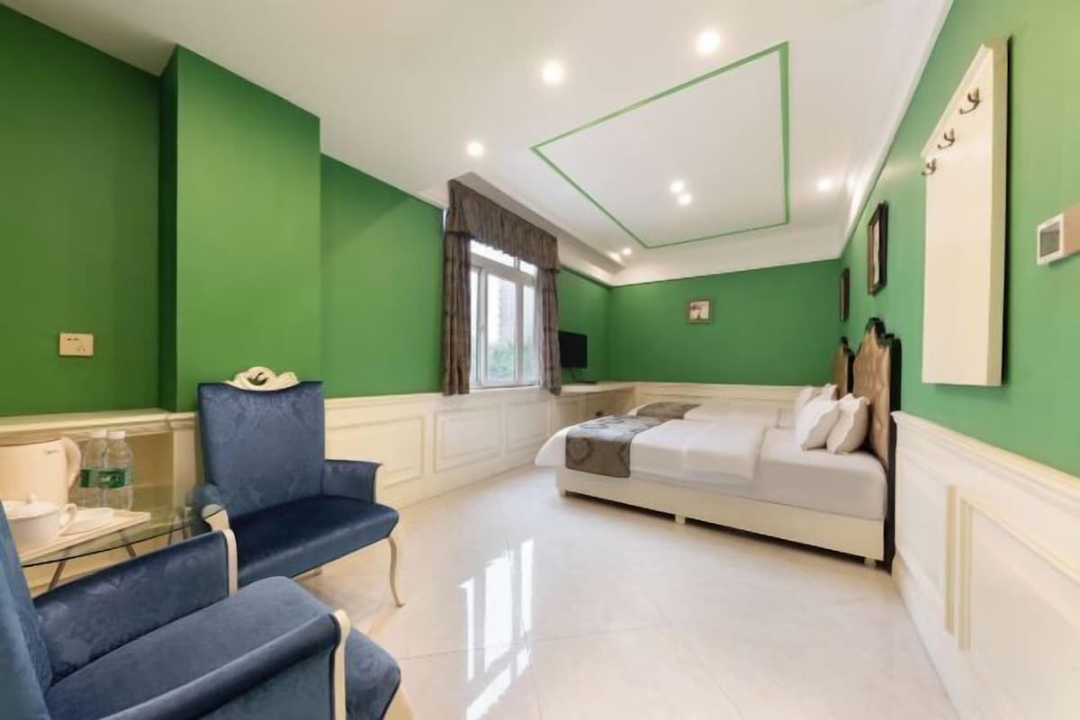 A room with a bed, a desk, and two chairs.