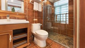 A modern bathroom with a wooden vanity, a toilet, a glass shower enclosure, and a large mirror. - Xiying Hotel (Ranjiaba Subway Station) (Chongqing)