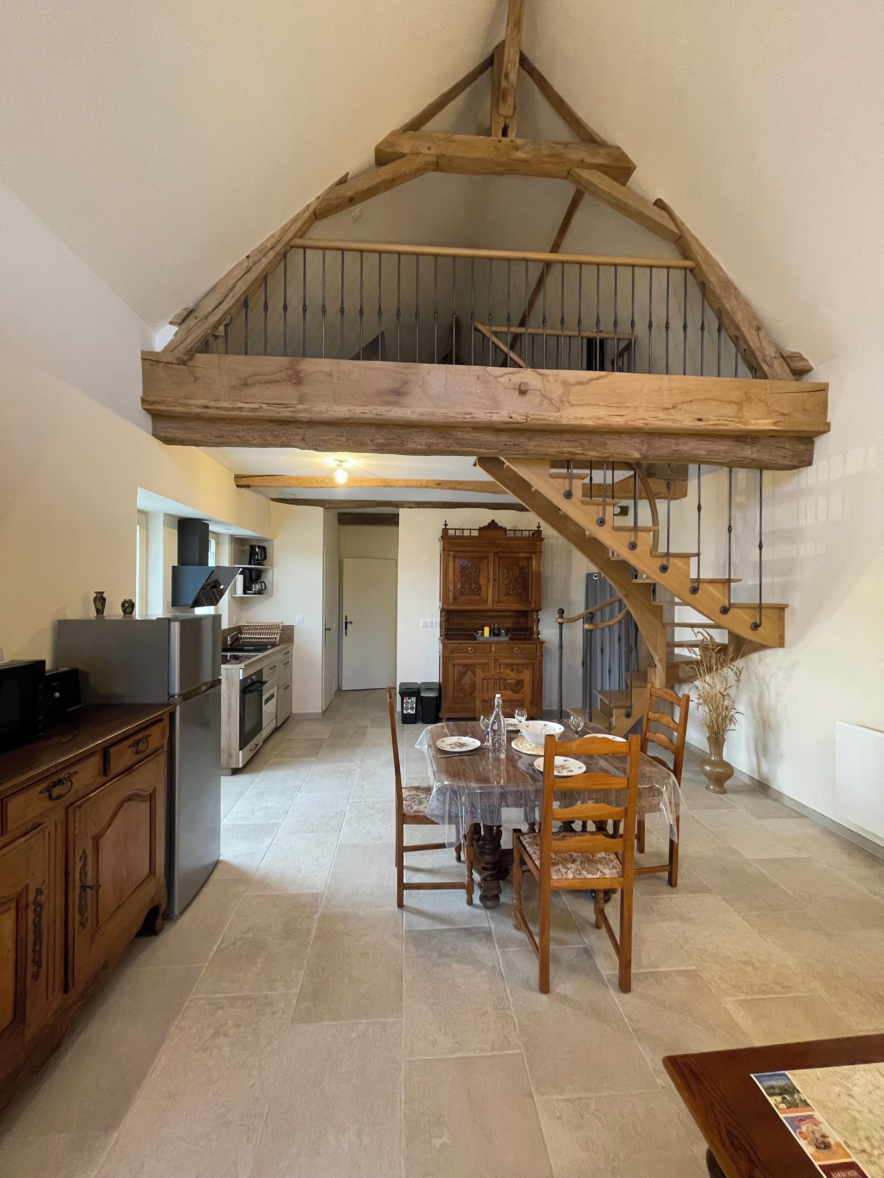 Une cuisine spacieuse avec un escalier en bois menant à un niveau supérieur.