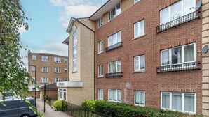 A multi-story residential building with brick facades, multiple windows, and balconies. - The Hackney Apartment (London)