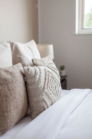 A bed with white bedding and textured pillows. - The Hackney Apartment (London)