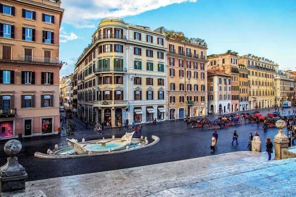 A historic square with a central fountain, surrounded by multi-story buildings with balconies and storefronts. - The Inn at the Spanish Steps Exclusive Collection - The Nest at The Spanish Steps (Rome)