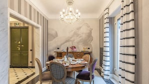 A dining area with a chandelier, a marble floor, and a wall mural. - The Inn at the Spanish Steps Exclusive Collection - The Nest at The Spanish Steps (Rome)