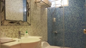 Une salle de bain avec un lavabo, des toilettes et une douche.