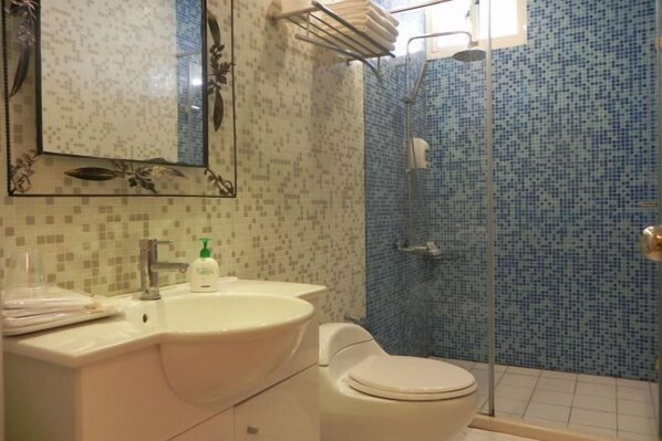 A bathroom with a sink, toilet, and shower.