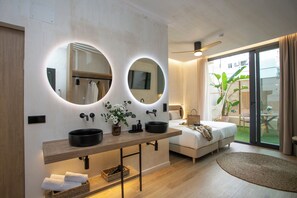 A modern bathroom with two large mirrors, a wooden vanity, and a large window with a view of a garden. - Nomad Haux Mestalla (Valencia)
