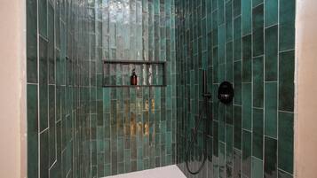 Tweepersoonskamer | Badkamer | Een douche, een haardroger, handdoeken, zeep