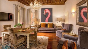 A dining area with wicker chairs, a wooden table, and a chandelier. - The Inn at the Spanish Steps Prestige Collection - The Pearl (Rome)
