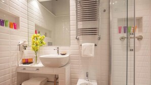 A modern bathroom with a white sink, mirror, and glass shower enclosure. - The Inn at the Spanish Steps Prestige Collection - The Pearl (Rome)