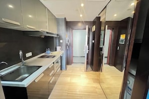A modern kitchen with a stainless steel sink, a countertop, and a wooden floor.