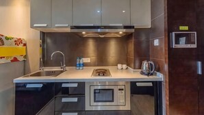 A modern kitchen with grey cabinets, a stainless steel sink, and an oven. - City Tribe Apartment (Nanjing Kairun Jincheng) (Nanjing)