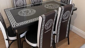 A dining table with six chairs, each with a black and white geometric pattern and the word "VERSACE" on the backrest. - 4 Beds, Sleeps 15, Near Lcy Airport & Excel London (London)