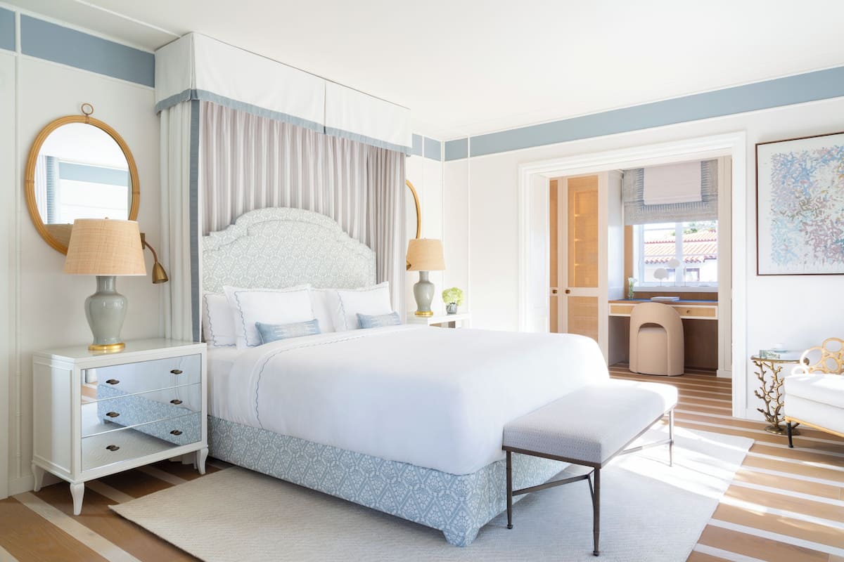 A bedroom with a bed, bedside tables, a desk, and a chair.