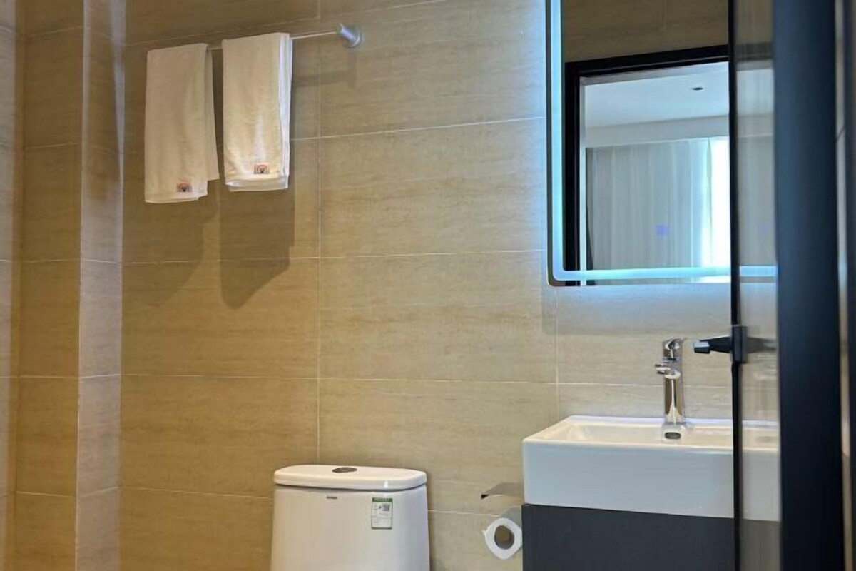 A bathroom with a toilet, sink, and a towel rack.