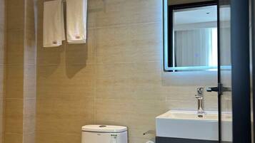 Une salle de bain équipée de toilettes, d’un lavabo et d’un porte-serviettes.