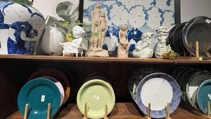 A display of ceramic plates and figurines on a shelf. - Jingdezhen International Youth Hostel (Jingdezhen)