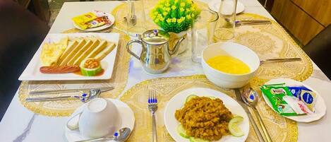 Una mesa de comedor dispuesta con varios platos, una jarra y un florero.
