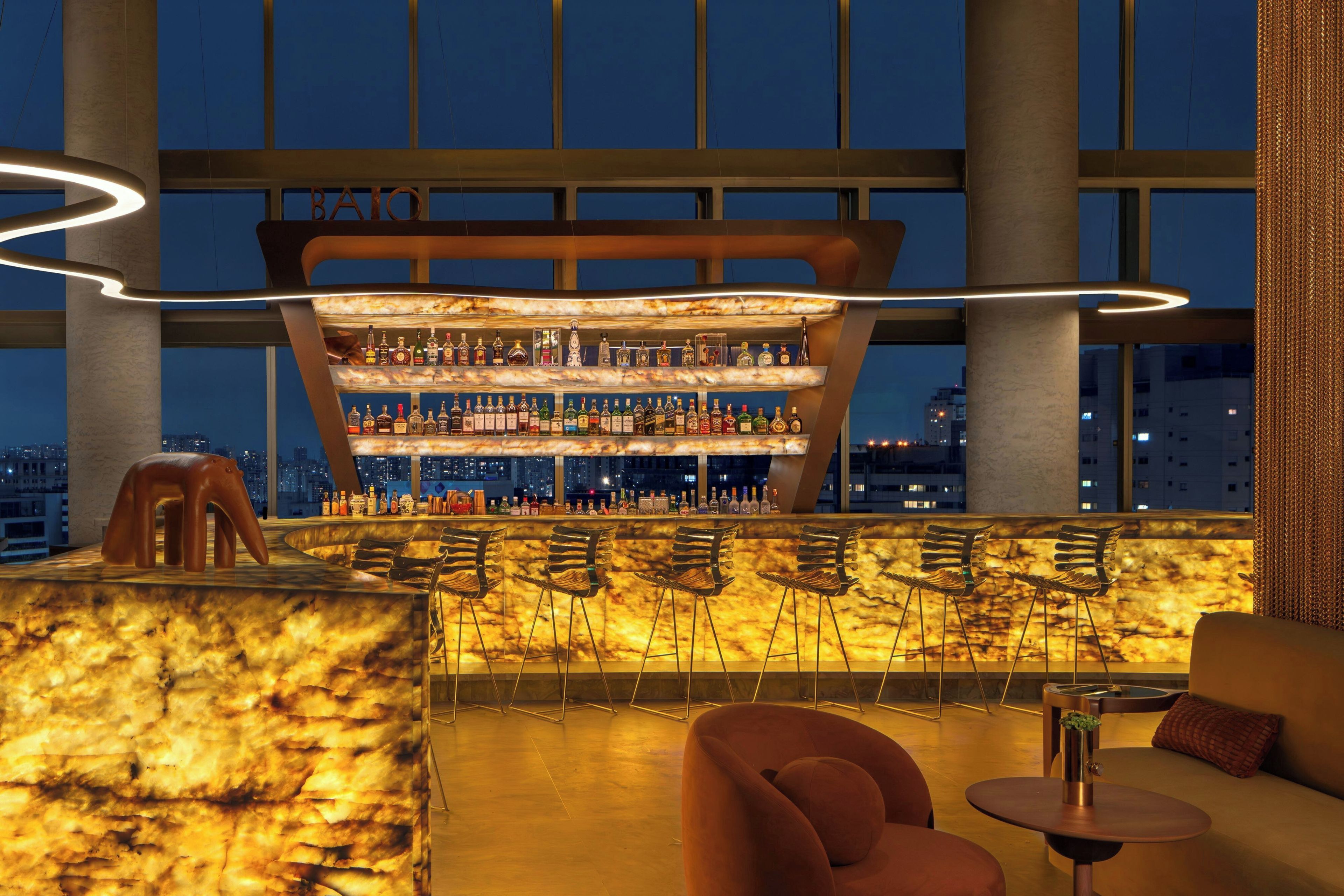 A bar area with a unique curved ceiling and a city view.