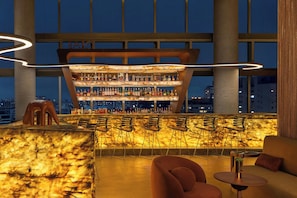 A bar area with a unique curved ceiling and a city view. - W São Paulo (São Paulo)