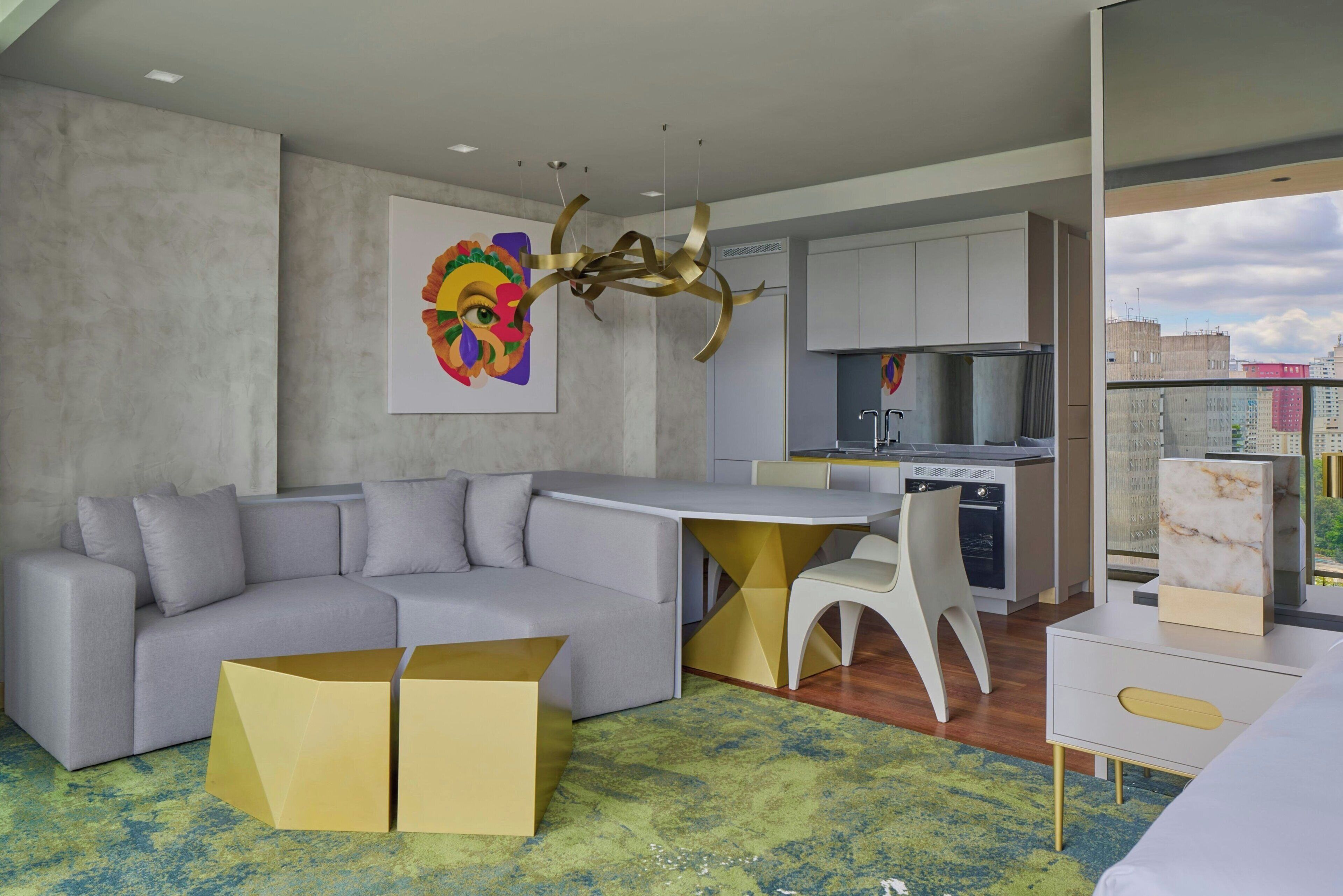 Un espacio habitable moderno con un sofá, una zona de comedor y una cocina.