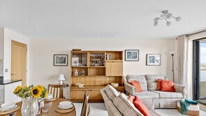 Un soggiorno con tavolo da pranzo, divano e una credenza in legno con ante in vetro.