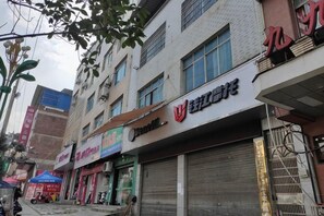Un immeuble à plusieurs étages, doté de différentes boutiques, dont une avec une enseigne bien visible indiquant qu’il s’agit d’un restaurant.