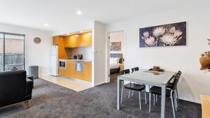 Un appartement moderne comprenant une cuisine, un coin repas et un salon.