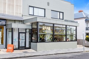 A modern building with a storefront named "Sisterhood."